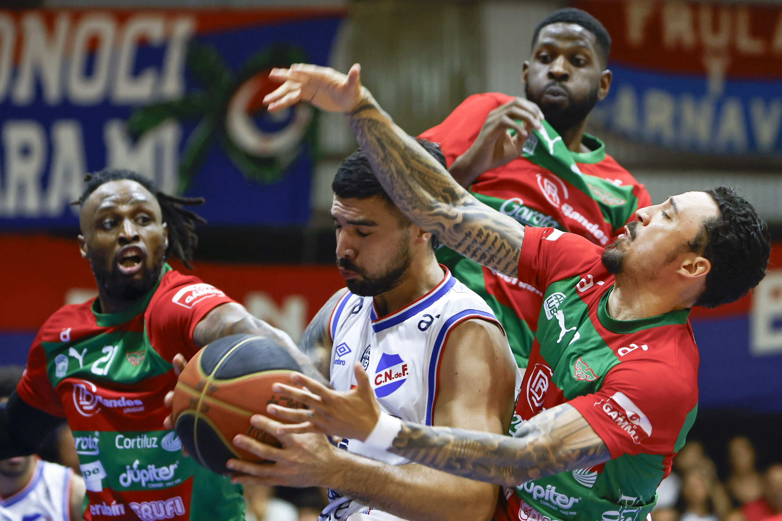 Ernesto Ryan-20250213ER-0005./ Sebastián Ottonello, de Nacional, entre Frank Hassell, Jamil Wilson y Donald Sims, de Aguada, durante el partido Nacional vs Aguada por la vigésima fecha de la Liga Uruguaya de Básquetbol, el 13 de febrero de 2025 en el Gran Parque Central, en Montevideo. / Foto: Ernesto Ryan, Agencia Gamba.-