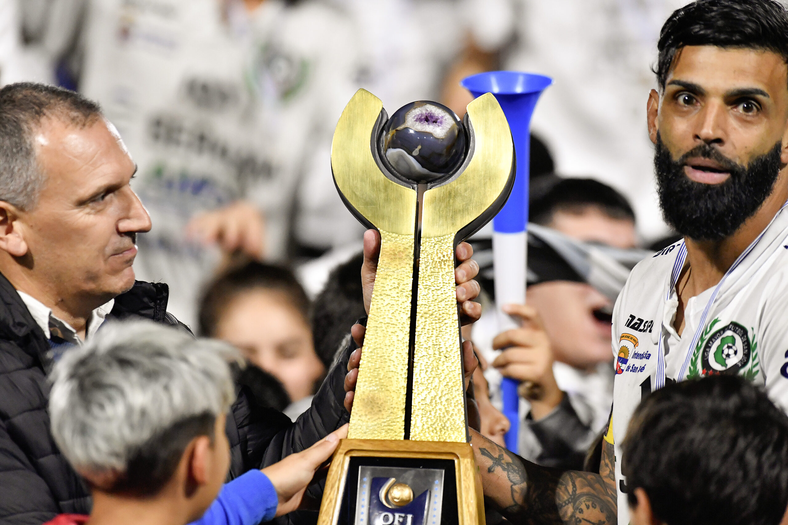 Fernando Morán-20250412FM-1874./ Sebastián Sosa, presidente de OFI, entrega el trofeo a Nicolás Rebollo, capitán de San José. San José Campeón de la 21ª Copa Nacional de Selecciones tras ganar en la segunda final 2 a 0 a Lavalleja, el 12 de abril de 2025 en el Estadio Casto Martínez Laguarda, en San José. / Foto: Fernando Morán, Agencia Gamba.-